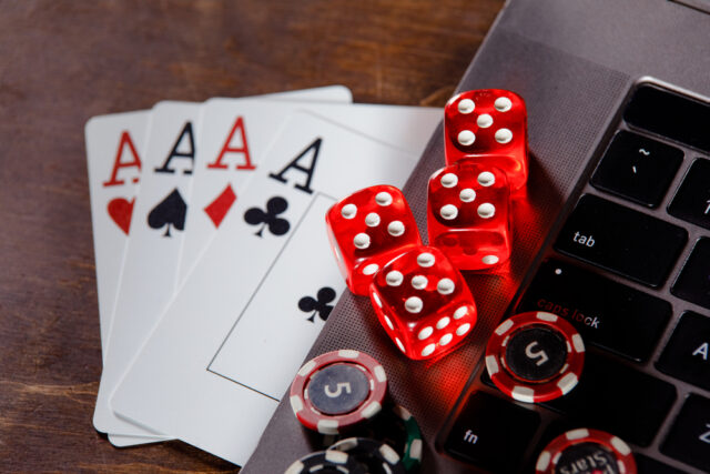 Red,playing,dice,,gambling,chips,and,cards,on,a,wooden